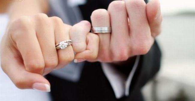 Đôi bàn tay của một cặp đôi đang nắm chặt vào nhau, tượng trưng cho hạnh phúc và sự gắn kết bền vững.