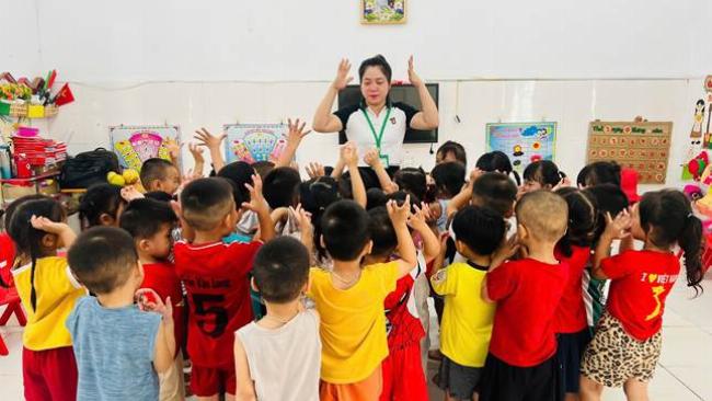 Các em bé vui vẻ nghe nhạc, vỗ tay và nhún nhảy theo giai điệu bài hát