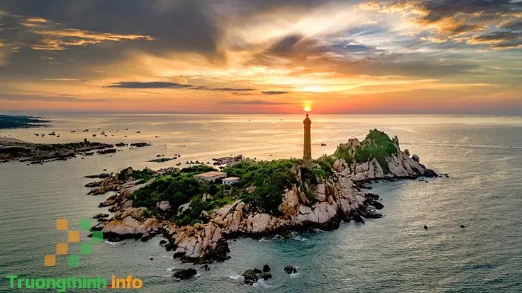 Đèn hiệu và những tảng đá lớn dưới ánh sáng bình minh, tạo nên hình ảnh tương phản mạnh
