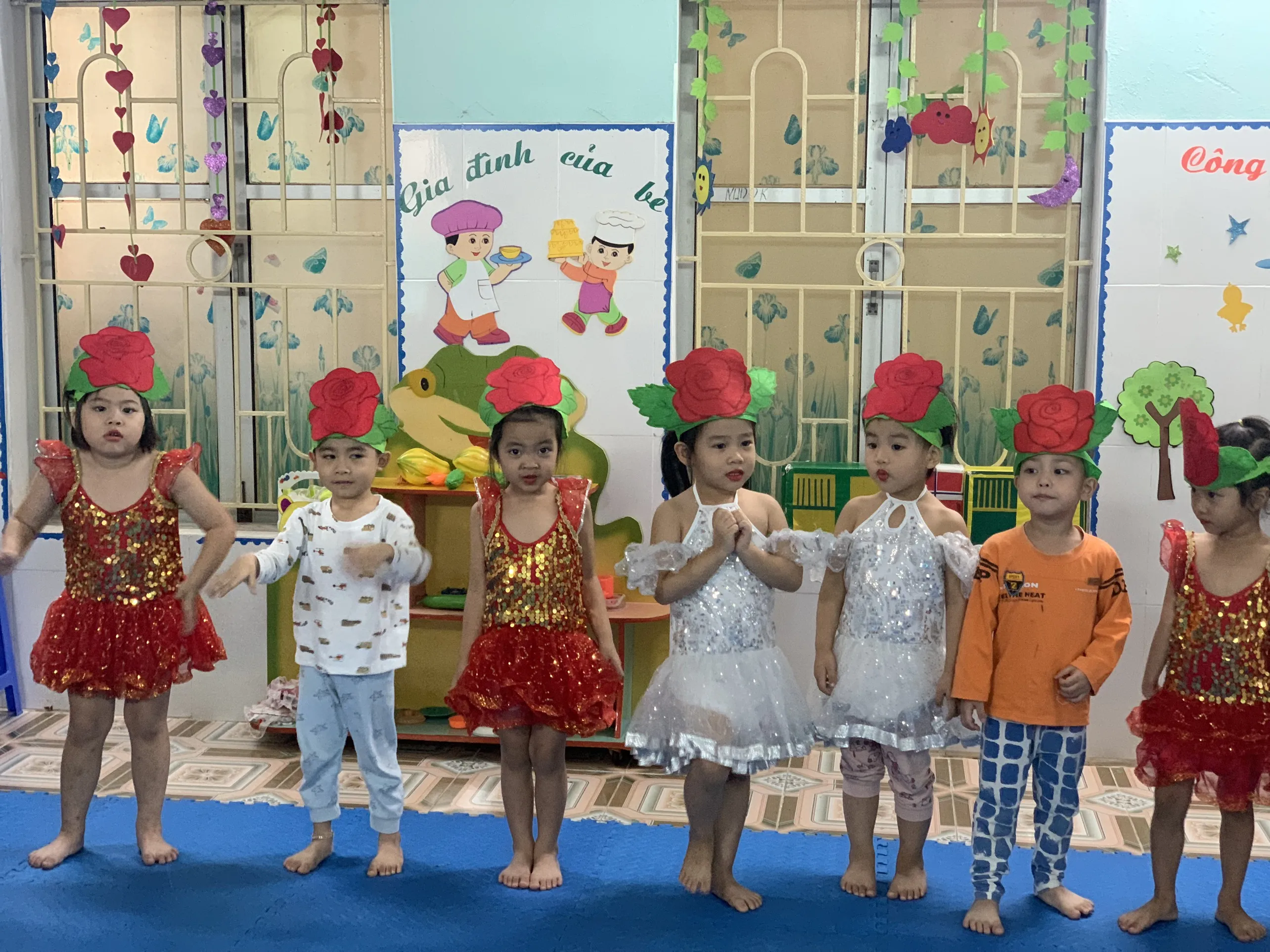 Một nhóm trẻ mầm non đang vui vẻ hát trong lớp học, thể hiện sự năng động và hào hứng khi dạy hát mời bạn ăn